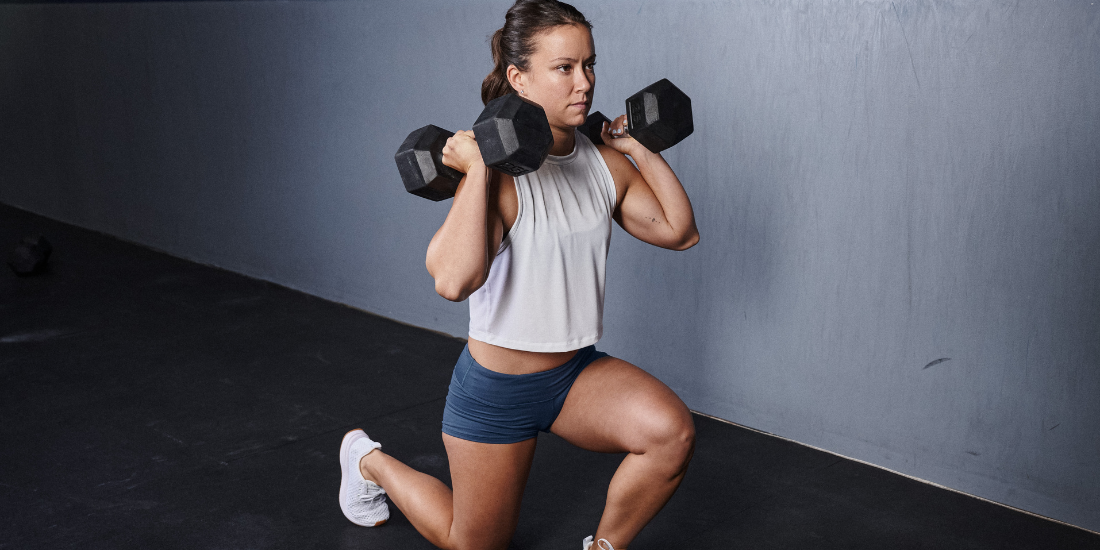 image of a lady going weighted lunges with the rubber dumbbells in a gym enviroment