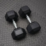 Pair of black dumbbells with '15KG' marking on a textured gray surface