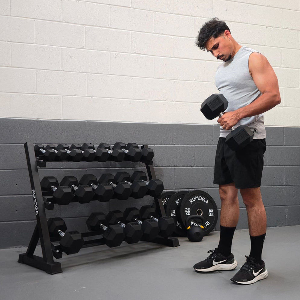 Man exercising with dumbbells in a gym setting