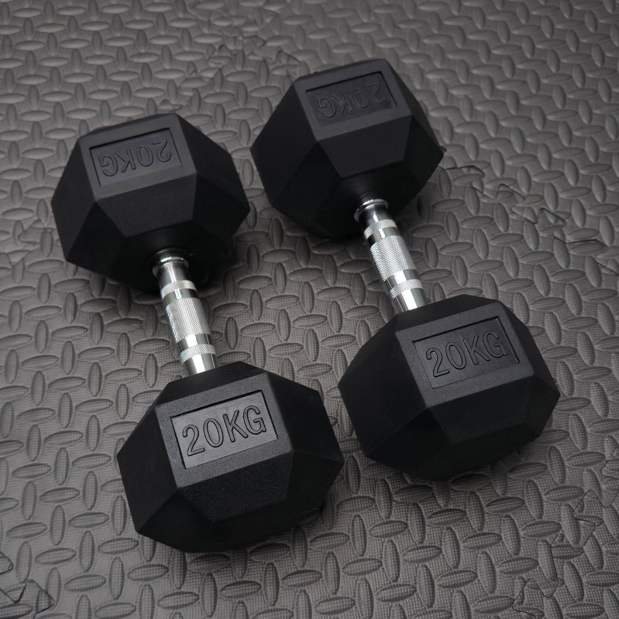 2 x 20kg rubber dumbbells on the textured flooring in the gmy