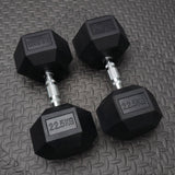 Pair of black dumbbells with '22.5KG' marking on a textured surface