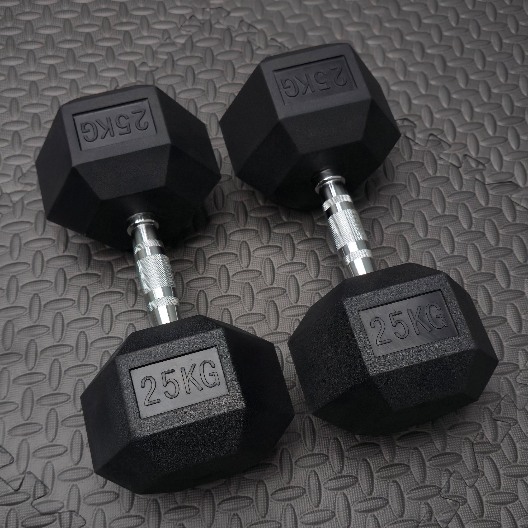 pair of 25kg rubber hex dumbbells on a textured gym flooring