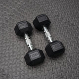 Pair of black rubber dumbbells with '7.5KG' marking on a textured gray surface